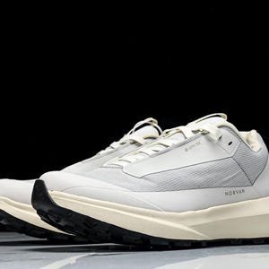 May include: Pair of light gray athletic shoes with black soles. The shoes have a textured upper and a thick, off-white midsole. The word "NORVAN" is printed on the side. The shoes are designed for outdoor activities.