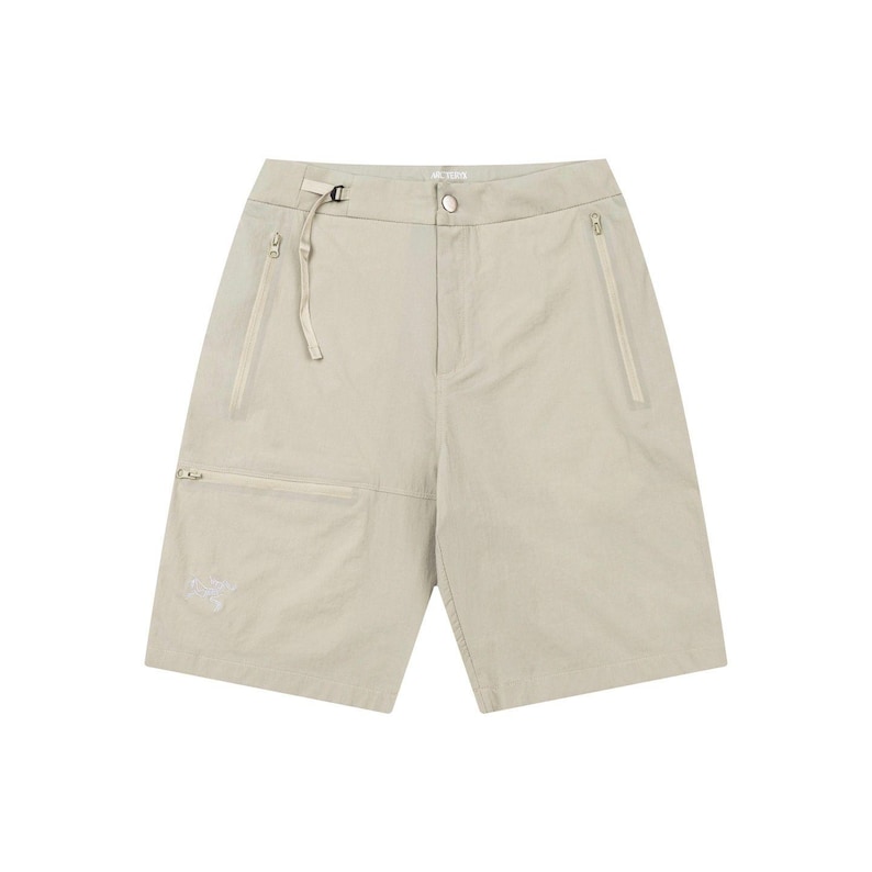 May include: Khaki-colored shorts with multiple pockets and a zip closure. The shorts have a belt loop with a buckle and a small logo on the front pocket. The fabric appears lightweight and suitable for warm weather.
