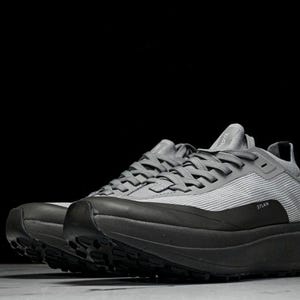 Puede incluir: Zapatillas deportivas grises con suelas negras. Las zapatillas tienen una parte superior texturizada y suelas gruesas. La palabra "STLAN" est&aacute; impresa en el lateral. Dise&ntilde;adas para correr u otras actividades deportivas.