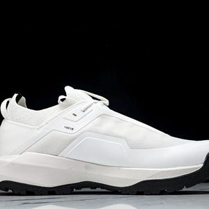 Puede incluir: Zapatilla deportiva blanca con suela negra. El calzado presenta un dise&ntilde;o aerodin&aacute;mico con una parte superior de malla y una suela gruesa y texturizada. Tiene una leng&uuml;eta en el tal&oacute;n y cierre de cordones. Dise&ntilde;ado para actividades deportivas.
