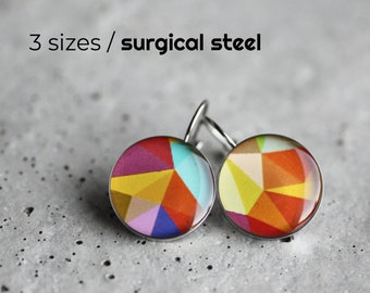 Puede incluir: Un par de pendientes geométricos coloridos hechos de acero quirúrgico. Los pendientes presentan un diseño multicolor con tonos de rojo, amarillo, azul, verde y morado.