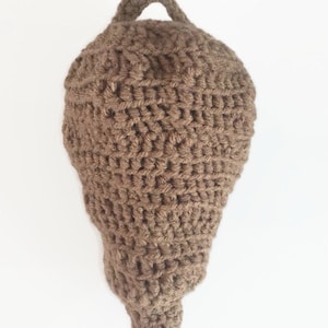 Puede incluir: Un adorno de ganchillo en forma de bellota de color marr&oacute;n con un lazo para colgar.