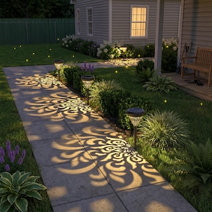 May include: Three solar-powered garden path lights with conical shades featuring intricate cut-out patterns. These lights are staked into the ground along a stone walkway, casting detailed, glowing floral-shaped shadows onto the pavement surface.
