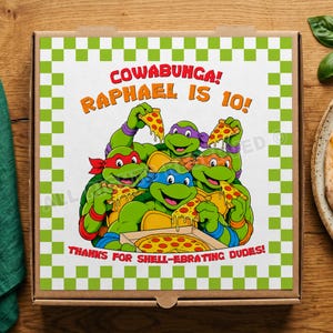 May include: A square cardboard pizza box featuring a green and white checkered border. The center displays four cartoon turtles eating pizza with the text: COWABUNGA! RAPHAEL IS 10! THANKS FOR SHELL-EBRATING DUDES! The design includes vibrant colors and pizza slices.