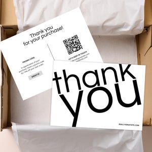May include: Two white rectangular cards with black text. One card features the words "thank you" in large bold letters and a website address. The other card includes "Thank you for your purchase!", a QR code, and a promo code box labelled "GREAT10".