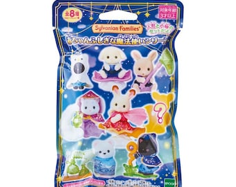 May include: A Sylvanian Families blind bag featuring eight collectible animal figures dressed in magical costumes. The blue packaging displays illustrations of various characters, including a rabbit, cat, and bear, with Japanese text and star motifs.