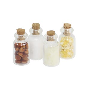May include: Four small clear glass bottles with cork stoppers. The first bottle contains brown seeds, the second holds a white powder, the third contains translucent white flakes, and the fourth is filled with small yellow crystalline fragments.