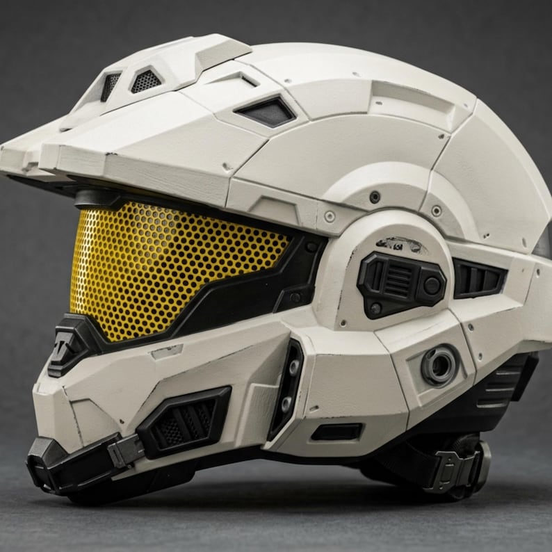 May include: A white and black helmet with a yellow mesh visor. The helmet has a futuristic design with multiple panels, vents, and a chin strap. The helmet appears to be made of a durable material.