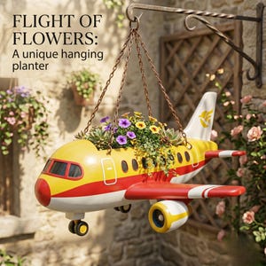 May include: A novelty hanging planter in the shape of a yellow and red aeroplane, filled with vibrant flowers and foliage. The planter is suspended by chains from a decorative metal hook. Text on the image reads "FLIGHT OF FLOWERS: A unique hanging planter."
