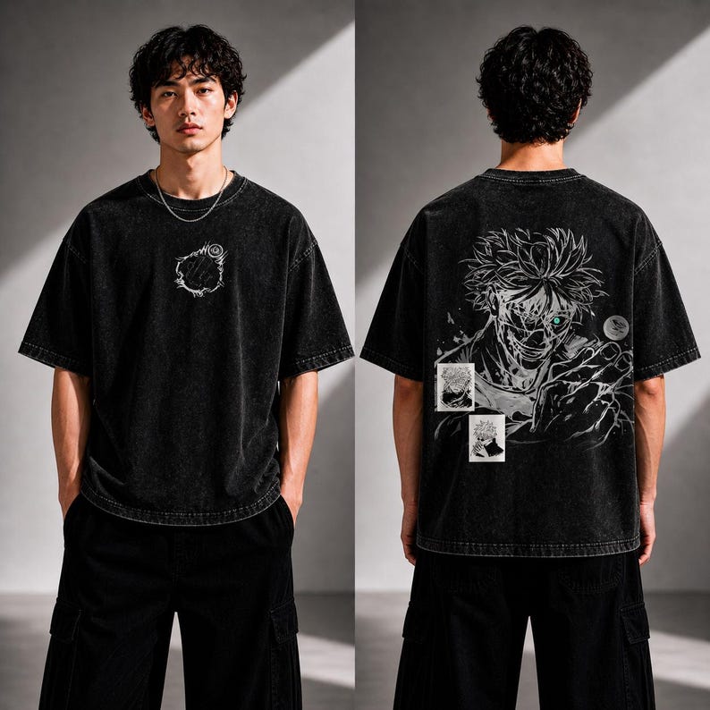 May include: Black oversized t-shirt with a distressed wash. The front features a white graphic. The back displays a detailed anime-style illustration with green eyes and two small images. The model is wearing black cargo pants.