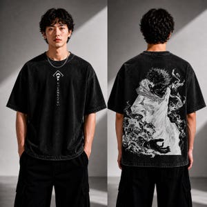 May include: Black, oversized t-shirt with a graphic on the front and back. The front features a white geometric design with Japanese text. The back displays a detailed black and white illustration of a character. The shirt is worn with black cargo pants.
