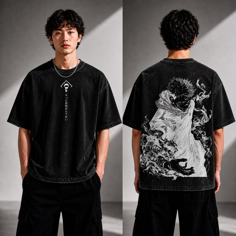 May include: Black, oversized t-shirt with a graphic on the front and back. The front features a white geometric design with Japanese text. The back displays a detailed black and white illustration of a character. The shirt is worn with black cargo pants.