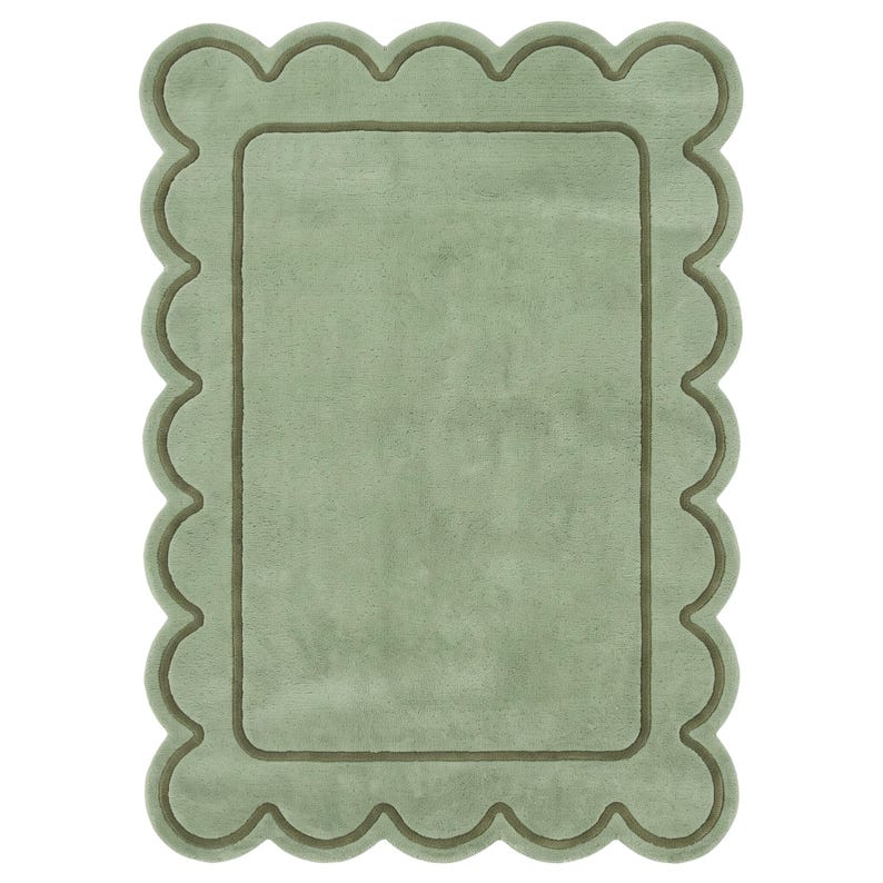 May include: A rectangular sage green rug featuring a scalloped edge design. The rug has a soft, plush texture with a darker green border that follows the scalloped perimeter, creating a distinct frame around the solid, light green center area.
