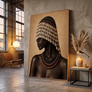May include: A large framed wall art print featuring a portrait of a person with dark skin wearing a headpiece made of numerous white cowrie shells and a multi-layered necklace consisting of black and metallic bronze spherical beads.