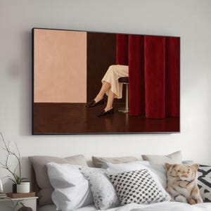 Può includere: Una stampa artistica da parete incorniciata che raffigura una scena con una gonna beige chiaro e mocassini neri su uno sgabello, posizionati dietro pesanti tende rosse. Lo sfondo presenta un design bicolore in pesca tenue e marrone scuro.