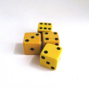 May include: Four yellow dice with black dots are arranged on a white surface. The dice are in various positions, showing different numbers of dots. The dice are a classic game accessory.