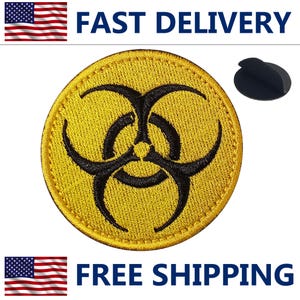 May include: A round, yellow embroidered patch with a black biohazard symbol. The patch has a stitched border and a black backing. The words "FAST DELIVERY" and "FREE SHIPPING" are displayed.