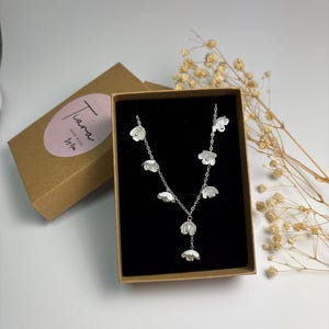 Peut inclure: Ensemble de trois mugs en céramique avec une finition mate et mouchetée. Les tasses sont de couleur crème, gris clair et gris foncé. Chaque mug a un design simple et minimaliste.