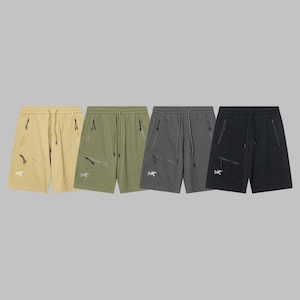 Pode incluir: Quatro pares de cal&ccedil;&otilde;es desportivos em v&aacute;rias cores: bege, verde-oliva, cinzento e preto. Cada par apresenta cintura com cord&atilde;o, bolsos com z&iacute;per e um log&oacute;tipo branco na perna esquerda. Os cal&ccedil;&otilde;es s&atilde;o feitos de um material leve, possivelmente nylon.