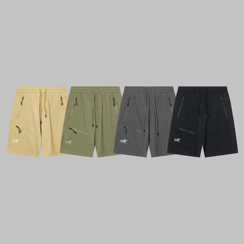 Pode incluir: Quatro pares de cal&ccedil;&otilde;es desportivos em v&aacute;rias cores: bege, verde-oliva, cinzento e preto. Cada par apresenta cintura com cord&atilde;o, bolsos com z&iacute;per e um log&oacute;tipo branco na perna esquerda. Os cal&ccedil;&otilde;es s&atilde;o feitos de um material leve, possivelmente nylon.
