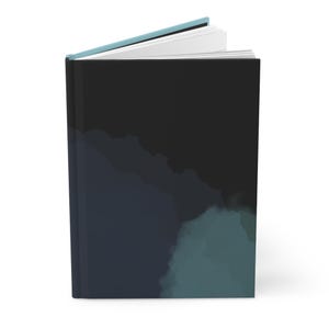 May include: A hardcover journal with a dark, abstract design. The cover features a gradient of black, navy, and teal watercolor-style paint. The top edge of the journal is a light blue color, and the pages are white.
