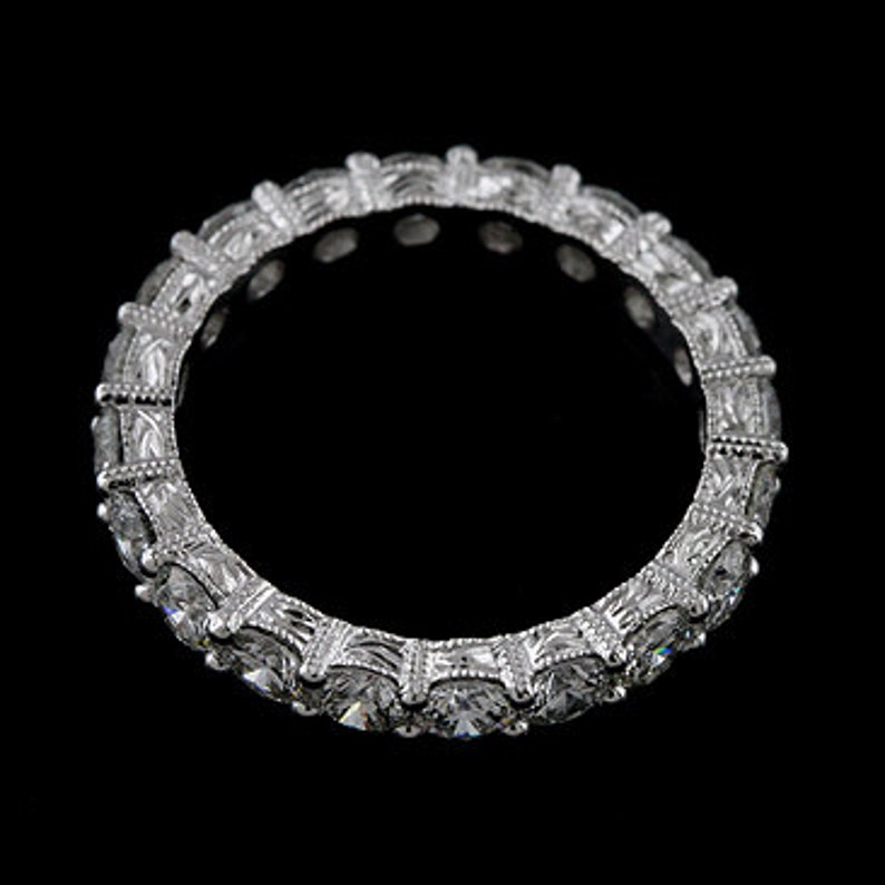 K&ouml;nnte beinhalten: Ein silberner Ewigkeitsring mit einer Reihe runder, klarer, gefasster Diamanten.