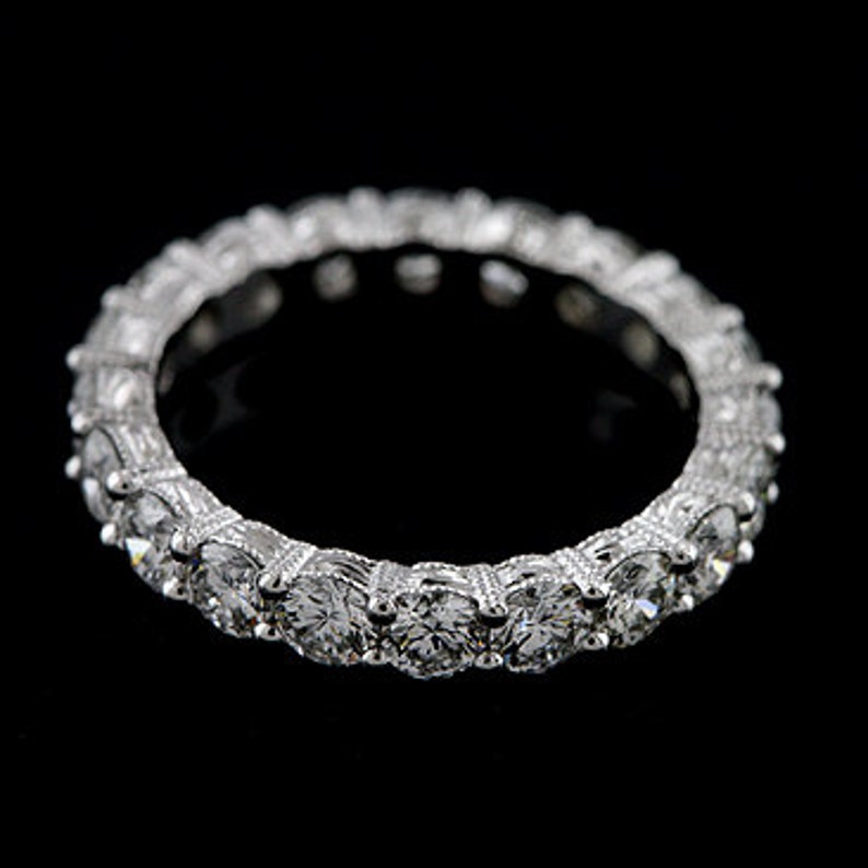 K&ouml;nnte beinhalten: Ein silberner Ewigkeitsring mit einer Reihe runder, klarer Diamanten.