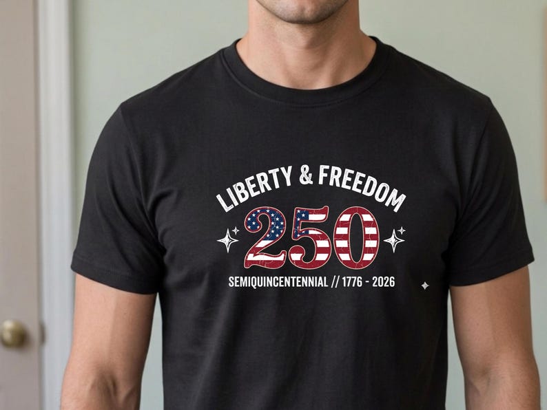 Puede incluir: Camiseta negra con el texto "LIBERTY & FREEDOM" sobre el n&uacute;mero "250" en rojo, blanco y azul, con el texto "SEMIQUINCENTENNIAL // 1776 - 2026" debajo.