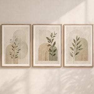 May include: A set of three framed wall art prints featuring vertical botanical illustrations of green leaves layered over beige and sage green arched shapes with fine line details. Each rectangular print is encased in a light wood frame.