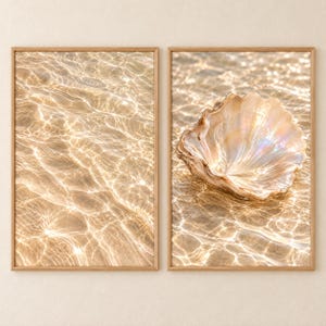 Könnte beinhalten: Zwei rechteckige Wandbilder in hellen Holzrahmen. Das linke Bild zeigt klares, flaches Wasser über goldenem Sand mit Sonnenlichtreflexionen. Das rechte Bild zeigt eine große, schillernde Muschel auf dem gleichen sandigen Meeresboden.
