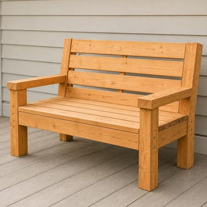 May include: A light brown wooden bench featuring a slatted backrest and a flat seat. The bench is constructed with thick, square-cut legs and armrests, showcasing a natural wood grain finish with visible metal hardware on the front support posts.