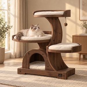 Puede incluir: Un árbol para gatos de varios niveles hecho de madera oscura con tres plataformas curvas, cada una con un cojín suave de color crema. Un gato peludo de pelo largo descansa en el nivel medio. Una pequeña pelota de juguete cuelga del nivel superior.