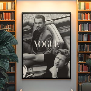 Könnte beinhalten: Schwarz-weiß gerahmtes Vogue-Magazin-Cover mit zwei Männern in einem Auto. Das Magazin-Cover wird an einer Wand in einem Raum mit Bücherregalen, einer Bank und einem Stuhl ausgestellt. Das Wort "VOGUE" ist deutlich sichtbar.