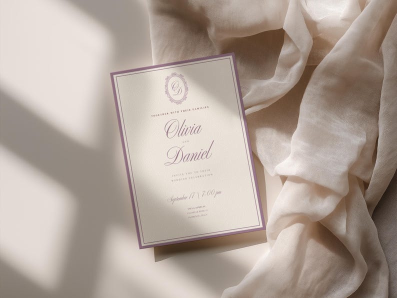 Puede incluir: Una tarjeta de invitaci&oacute;n de boda rectangular con fondo color crema y un borde fino de color morado. El texto dice Together with their families, Olivia and Daniel, invite you to their wedding celebration, September 17, 7:00 pm, con un monograma.