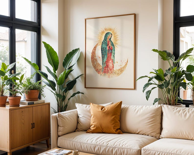 Puede incluir: Una l&aacute;mina de arte mural enmarcada con una ilustraci&oacute;n en acuarela de la Virgen de Guadalupe de pie sobre una luna creciente con un halo de rayos dorados detr&aacute;s de su cabeza, en tonos verde azulado, rojo y dorado sobre fondo claro.