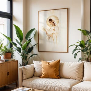 May include: A framed wall art print featuring a stylised illustration of a figure with a golden halo, wearing white robes and holding a white dove. The artwork uses soft gold and white tones, presented in a thin wooden frame on a plain wall.