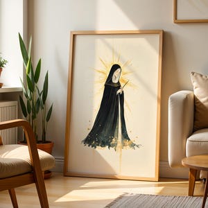 Puede incluir: Una l&aacute;mina de arte mural enmarcada que presenta una ilustraci&oacute;n estilizada de una figura con una larga capa negra con capucha. La figura est&aacute; rodeada por un halo dorado de rayos solares, con salpicaduras de pintura dorada en la base de la capa.