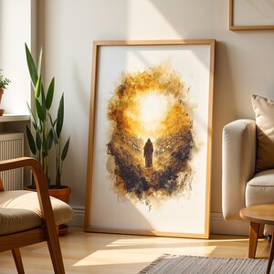 K&ouml;nnte beinhalten: Ein gerahmter vertikaler Kunstdruck mit einer Illustration im Aquarellstil, die eine einsame Gestalt auf einem Feld zeigt, welche einem hellen, leuchtenden goldenen Sonnenstrahl zugewandt ist, umgeben von dunklen, texturierten Pinselstrichen.