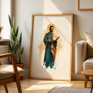 Peut inclure: Une impression d'art murale encadr&eacute;e repr&eacute;sentant une illustration &agrave; l'aquarelle d'un personnage barbu v&ecirc;tu d'une robe bleu sarcelle et d'une cape dor&eacute;e, tenant un livre ouvert. Le personnage porte une aur&eacute;ole dor&eacute;e sur fond clair.