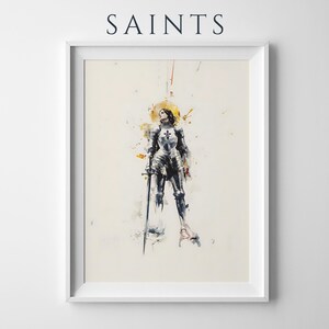 Peut inclure: Une impression d'art encadr&eacute;e intitul&eacute;e SAINTS repr&eacute;sentant une illustration &agrave; l'aquarelle d'une silhouette en armure de plaques argent&eacute;e tenant une longue &eacute;p&eacute;e. La silhouette a un halo dor&eacute; derri&egrave;re la t&ecirc;te, avec des &eacute;claboussures de peinture jaune, grise et noire.
