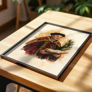 May include: A framed watercolour-style print depicting a historical figure wearing a dark cap and a red and gold robe. The figure holds an open book in one hand and a green palm frond in the other, with a faint golden halo visible above the head.