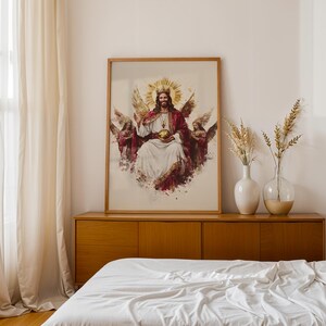 May include: A framed wall art print featuring a central figure with a golden crown and halo, wearing a white robe and red cloak, holding a golden orb. The figure is flanked by two winged angels on each side, rendered in a painterly style with warm tones.