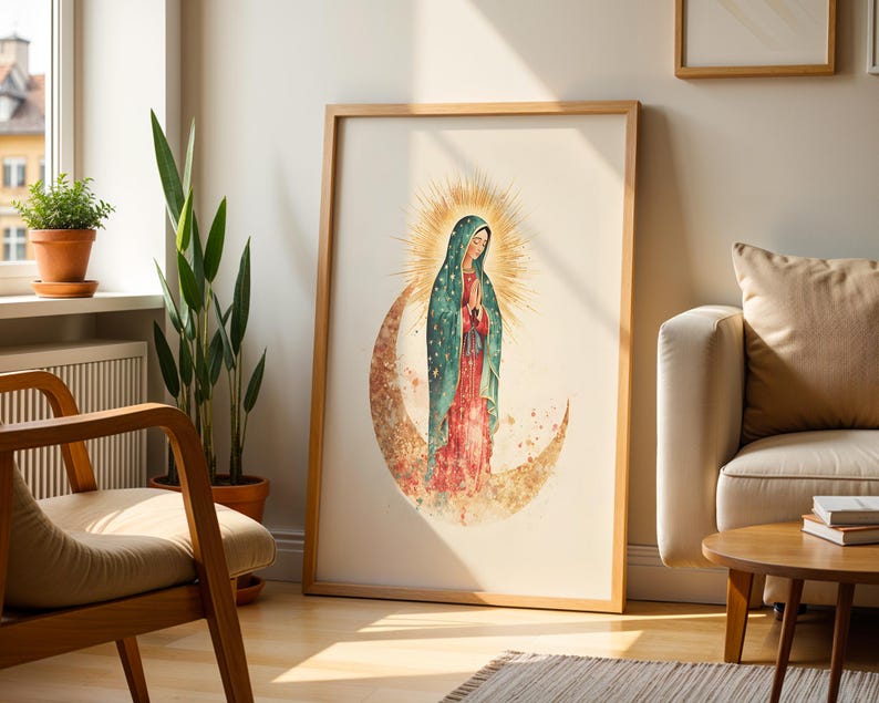 May include: A framed wall art print featuring a watercolor illustration of the Virgin of Guadalupe. She wears a teal cloak with gold stars over a red dress, standing on a crescent moon with a radiant golden sunburst halo behind her head.