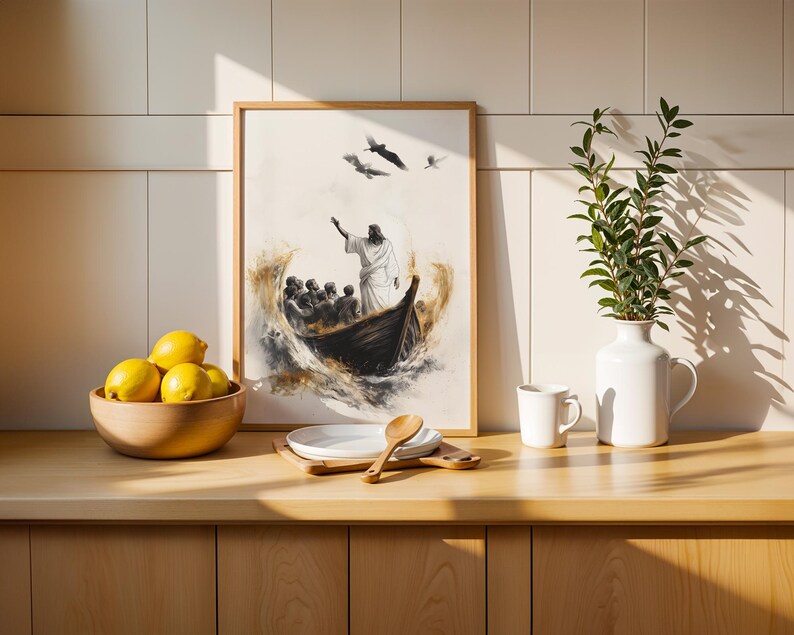 May include: A framed wall art print depicting a figure standing in a boat with a group of people, surrounded by turbulent water and birds in flight. The artwork features a neutral colour palette with dark brown and gold accents on a white background.