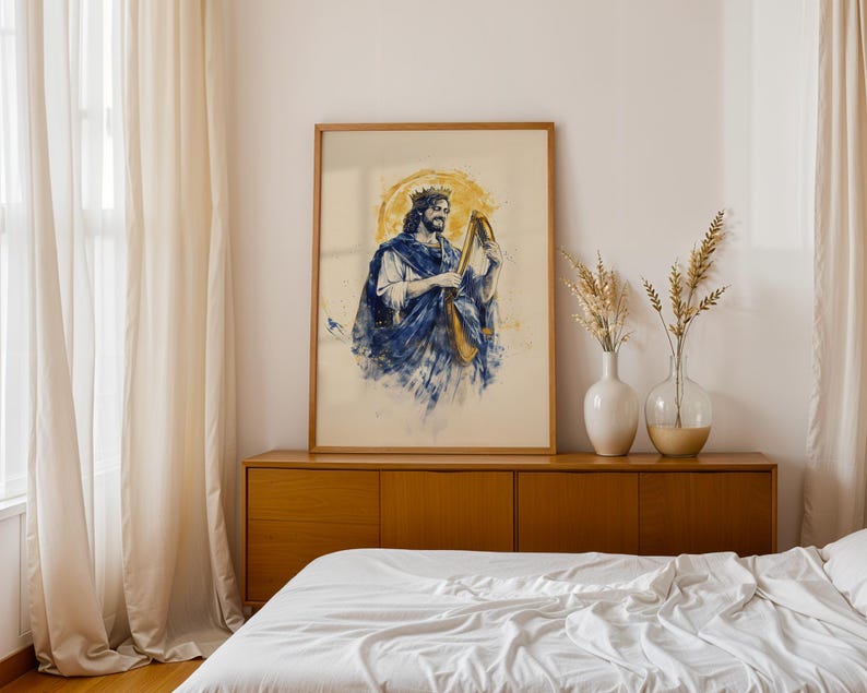 K&ouml;nnte beinhalten: Ein gerahmter Kunstdruck mit einer Illustration im Aquarellstil, die eine b&auml;rtige Figur mit Krone und blauem Gewand zeigt, die eine Harfe spielt. Die Figur ist vor einem kreisf&ouml;rmigen goldenen Hintergrund mit blauen Farbspritzern dargestellt.