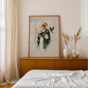 Pu&ograve; includere: Una stampa incorniciata in stile acquerello che raffigura una figura con una veste verde scuro e un'aureola dorata, intenta a leggere un libro aperto, accompagnata da un uccello in volo. L'opera &egrave; presentata in una cornice di legno chiaro.