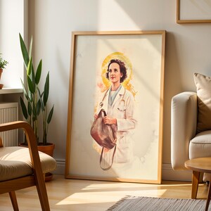 May include: A framed vertical art print featuring a watercolor-style illustration of a medical professional in a white coat with a stethoscope around their neck, holding a brown bag, set against a soft yellow halo background on a white canvas.