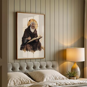 Peut inclure: Une impression d'art encadr&eacute;e repr&eacute;sentant une figure barbue v&ecirc;tue d'une robe &agrave; capuche marron fonc&eacute;, &eacute;crivant dans un livre ouvert avec un halo dor&eacute; derri&egrave;re la t&ecirc;te. L'&oelig;uvre est pr&eacute;sent&eacute;e dans un cadre en bois sur un mur lambriss&eacute;.