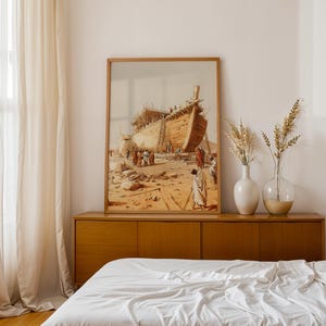 May include: A framed wall art print depicting a large wooden ship under construction in a desert landscape with figures in robes standing nearby. The artwork features warm beige, brown, and tan tones, showcasing a detailed historical scene.