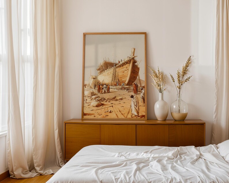 May include: A framed wall art print depicting a large wooden ship under construction in a desert landscape with figures in robes standing nearby. The artwork features warm beige, brown, and tan tones, showcasing a detailed historical scene.
